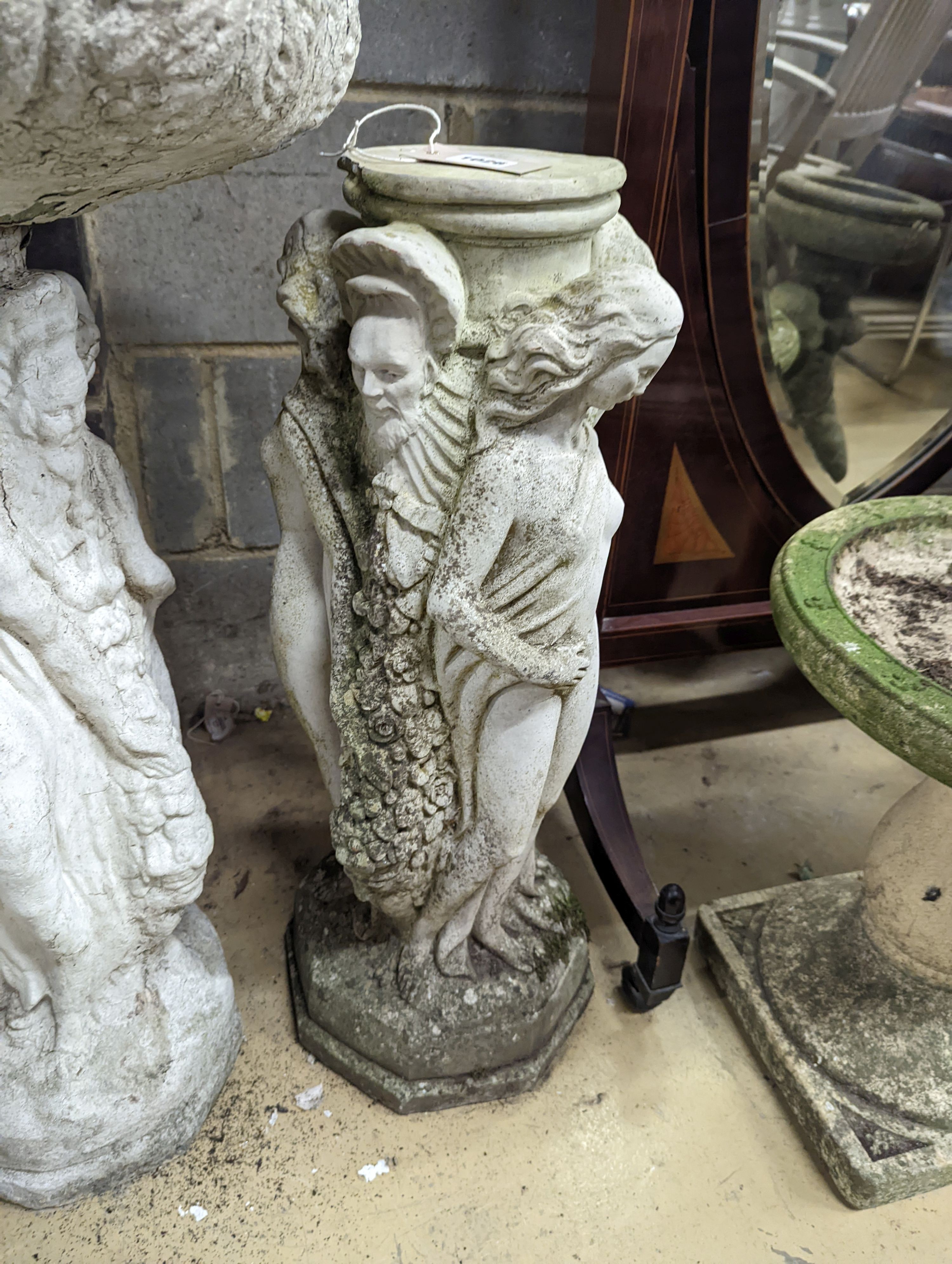 A circular reconstituted stone figural garden planter, diameter 48cm, height 82cm together with two stone bird baths and a plinth